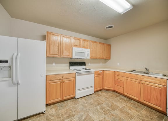 a kitchen with white appliances and wooden cabinets