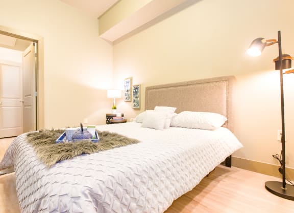 a bedroom with a large bed with a white comforter and pillows at Sugar House Apartments By Urbana, Salt Lake City, UT, 84105