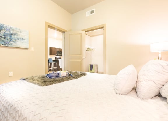 a bedroom with a large bed and a door to a bathroom at Sugar House Apartments By Urbana, Salt Lake City, UT, 84105