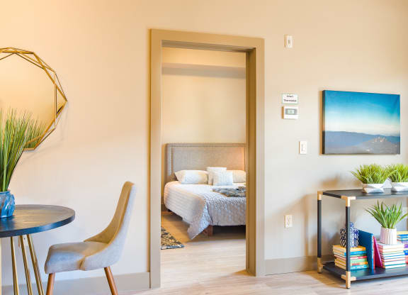 a bedroom with a bed and a table and a mirror at Sugar House Apartments By Urbana, Salt Lake City, UT, 84105