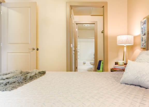 a bedroom with a large bed and a mirror in the closet at Sugar House Apartments By Urbana, Salt Lake City, UT, 84105