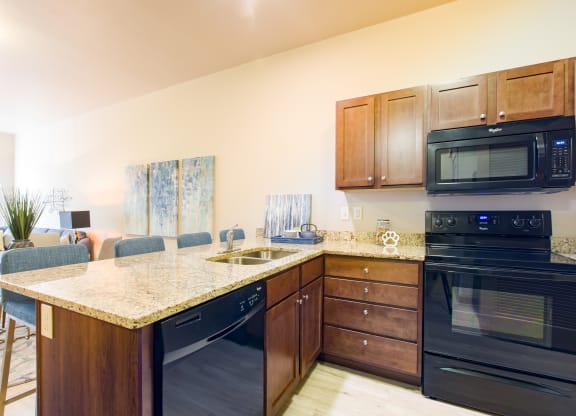 a kitchen with black appliances and a granite counter top at Sugar House Apartments By Urbana, Salt Lake City, UT, 84105