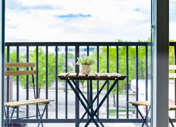 a patio with a table and chairs on a balcony at Sugar House Apartments By Urbana, Salt Lake City, UT, 84105