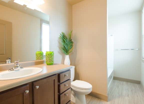 a bathroom with a toilet and a sink and a mirror at Sugar House Apartments By Urbana, Salt Lake City, UT, 84105