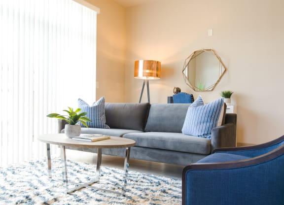 a living room with a gray couch and blue chairs at Sugar House Apartments By Urbana, Salt Lake City, UT, 84105