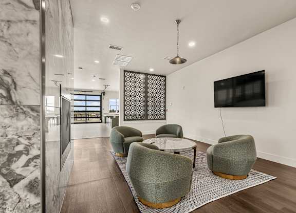 A modern living room with a grey sofa and a TV on the wall.