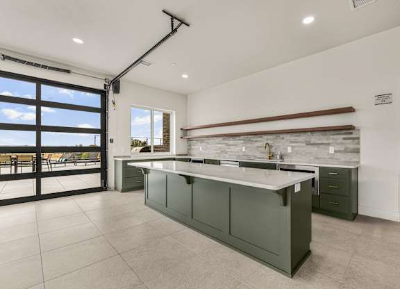 A modern kitchen with a large island and a view of the outdoors.