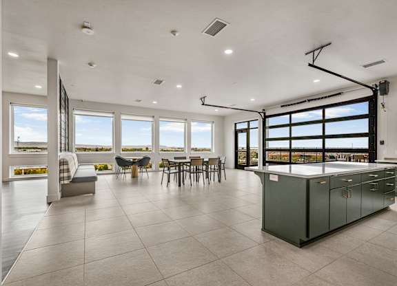 A modern kitchen with a large island and a view of the ocean.