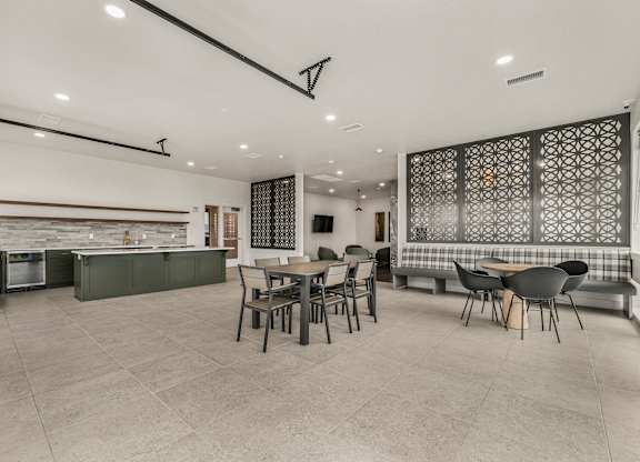 A modern kitchen with a dining area and a patterned backsplash.