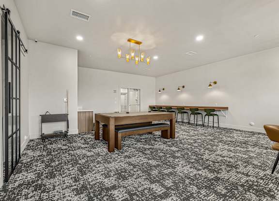 A room with a grey carpet and a wooden table.