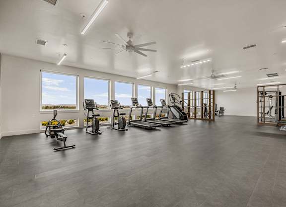 A spacious gym with a variety of equipment including treadmills, stationary bikes, and weight machines.