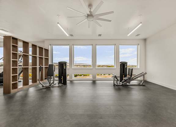 A spacious room with a ceiling fan and two treadmills.