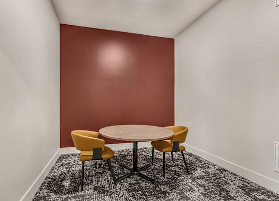A round table with four chairs around it in a room.