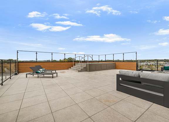 A rooftop patio with a table and chairs.