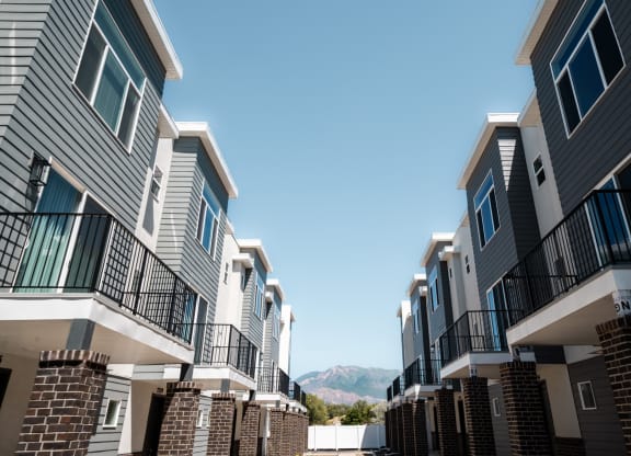 a row of apartment buildings with mountains in the background