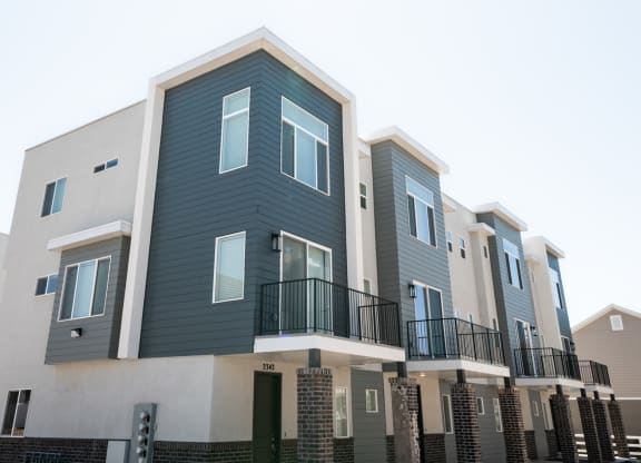 a row of apartment buildings with blue and white siding