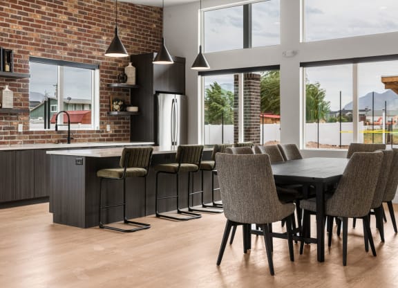 a kitchen with a large table and chairs in front of a brick wall