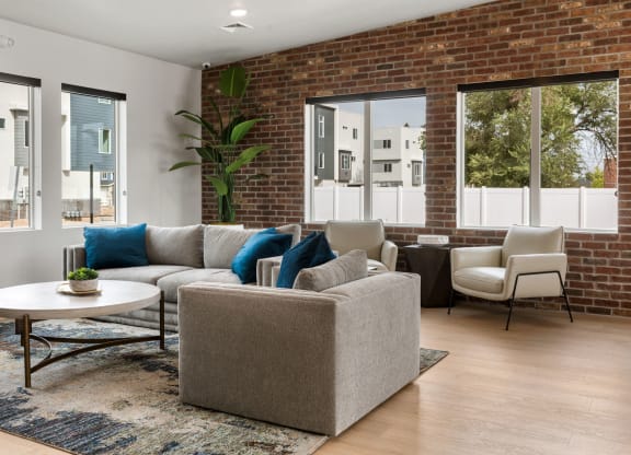 a living room with a brick wall and large windows