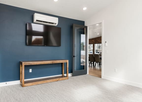 a living room with a tv and a door to a dining room