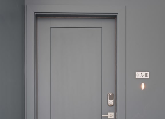 a gray door with a white door frame and a wooden floor