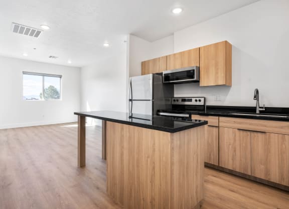 a kitchen with a black counter top and wooden cabinets