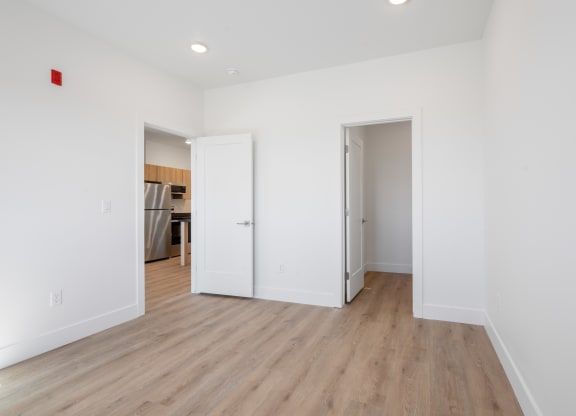 a renovated living room with white walls and wood flooring