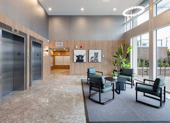 A spacious waiting area with two elevators and a seating area.