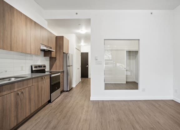 a kitchen and living room with wood flooring and white walls