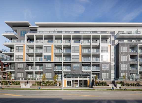 A modern apartment building with balconies and multiple floors.