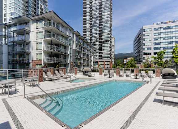 A large swimming pool in front of apartment buildings.
