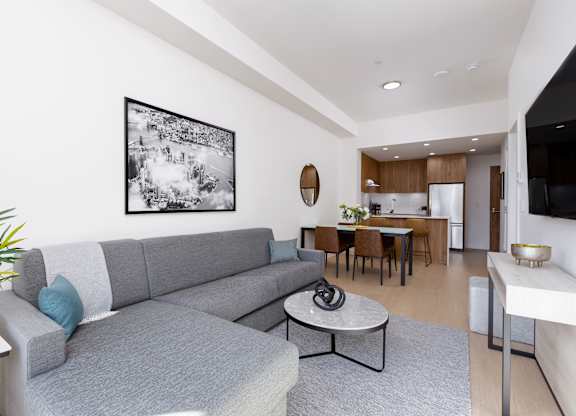 A modern living room with a grey couch and a coffee table.