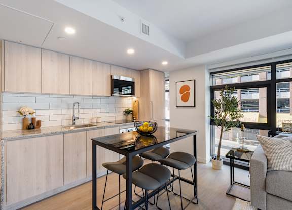 A modern kitchen with a dining table and chairs.