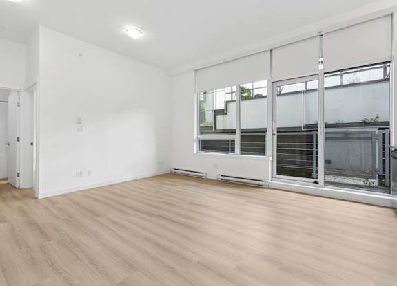 A room with a white wall and a wooden floor.