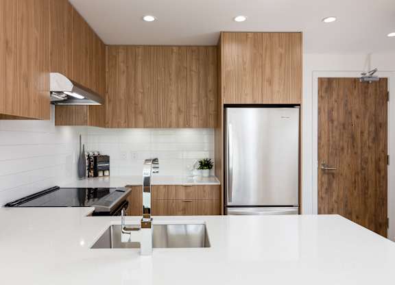 A modern kitchen with wooden cabinets and stainless steel appliances.