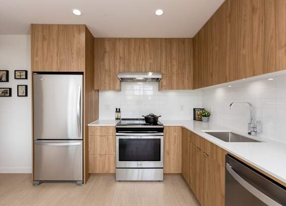 A modern kitchen with wooden cabinets and stainless steel appliances.