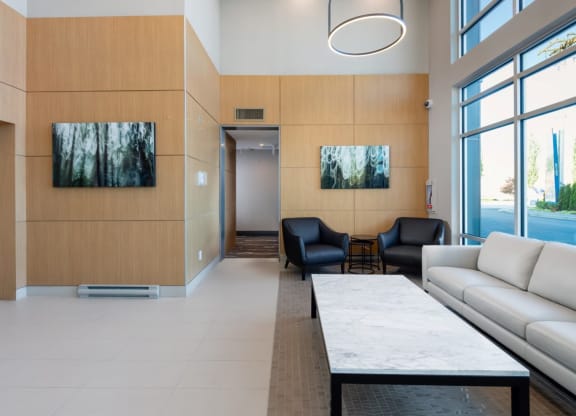the lobby of a building with couches and a table