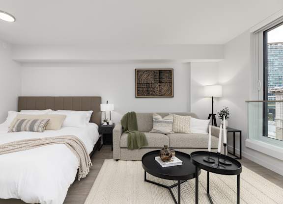 A modern bedroom with a large bed and a couch.