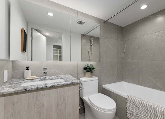 A bathroom with a toilet, sink, and bathtub.