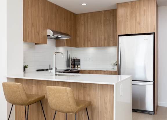 A modern kitchen with wooden cabinets and a white countertop.