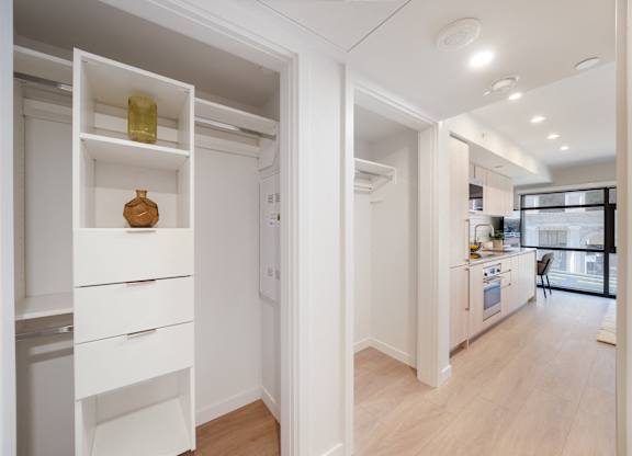 A kitchen with white cabinets and a wooden floor.