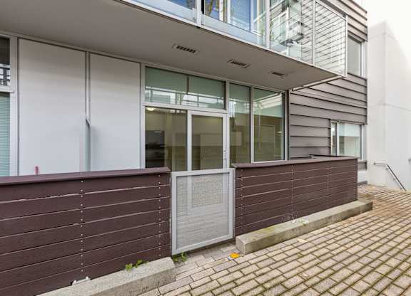 A building with a brown wall and a grey door.