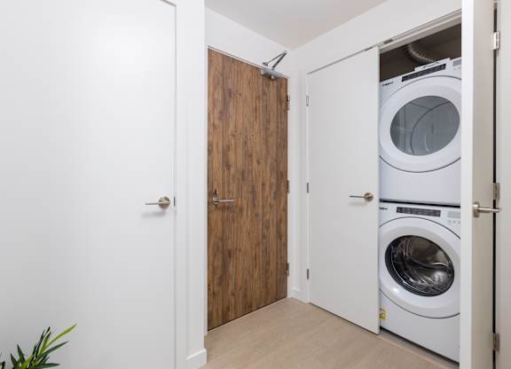 A white door is open to a laundry room with a washer and dryer.