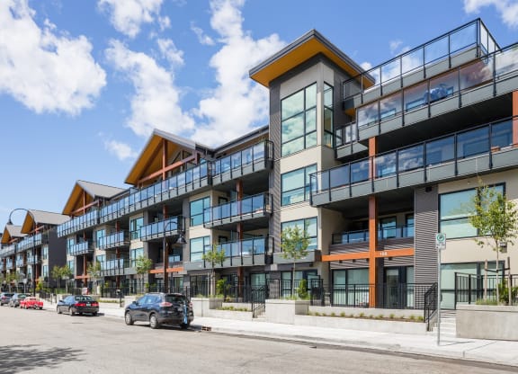 a large apartment building with cars parked in front of it