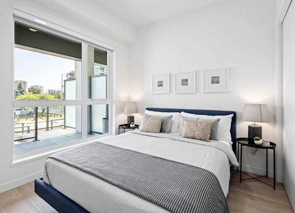 A bedroom with a large bed and a view of the outside.