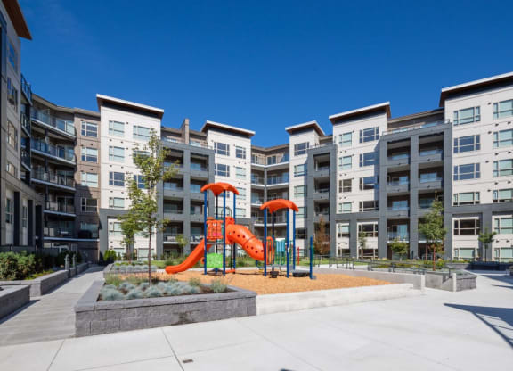 an apartment building with a playground in the middle of it