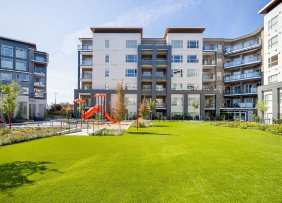 a grassy area in front of an apartment building