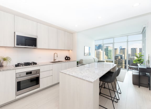 a kitchen with white cabinets and a marble counter top
