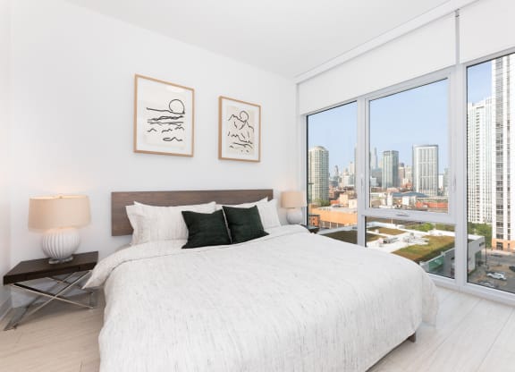 a bedroom with a large bed next to a window