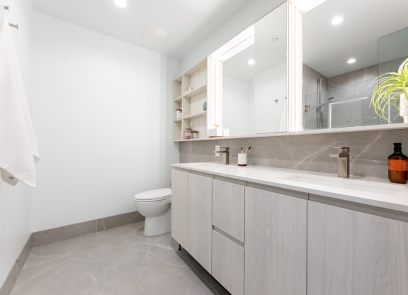 a bathroom with white cabinets and a white toilet