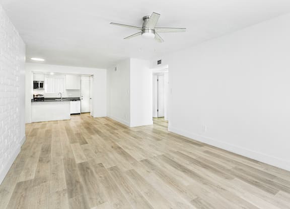A room with a ceiling fan and wooden flooring.